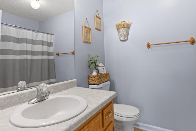 bathroom with vanity, a textured ceiling, and toilet