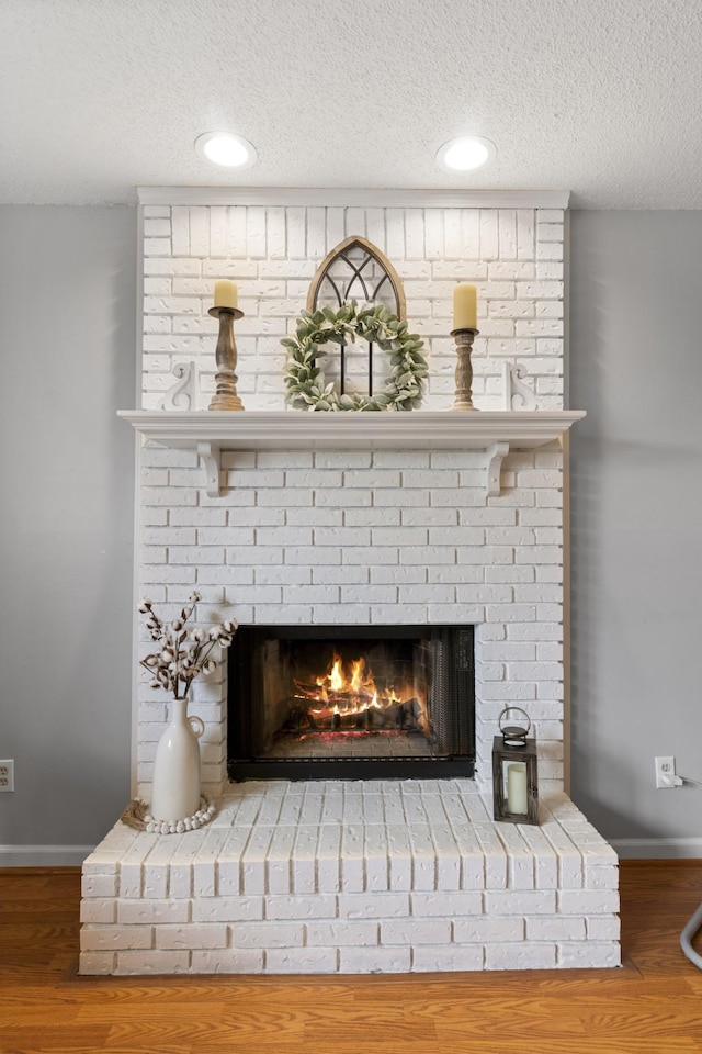 room details with hardwood / wood-style flooring, a fireplace, and a textured ceiling