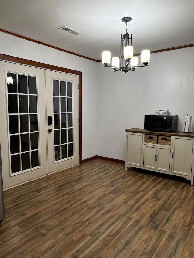 unfurnished dining area with ornamental molding, dark hardwood / wood-style floors, and french doors