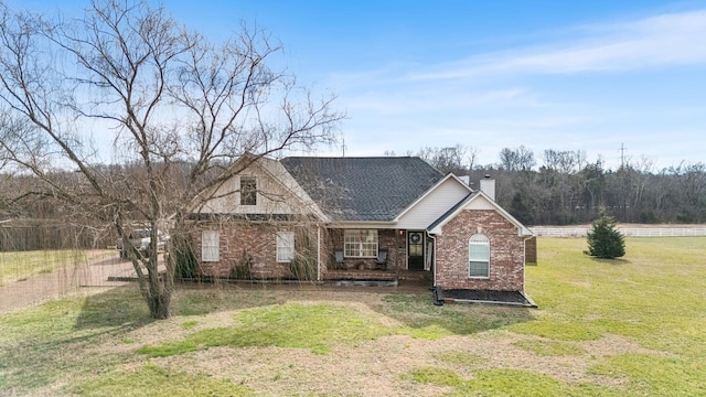 view of front of property featuring a chimney, roof with shingles, fence, a front lawn, and brick siding