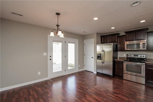 kitchen featuring dark brown cabinetry, pendant lighting, dark hardwood / wood-style flooring, and appliances with stainless steel finishes