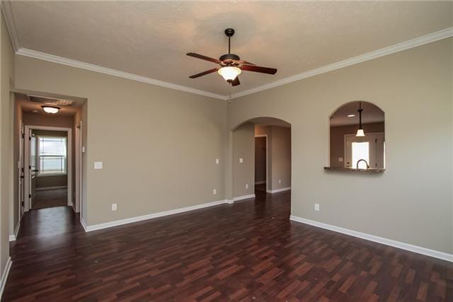 unfurnished room with dark hardwood / wood-style flooring, ornamental molding, and ceiling fan