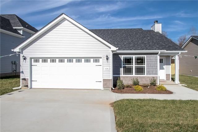 view of front of home with a garage and a front lawn