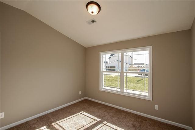 spare room with vaulted ceiling and carpet flooring