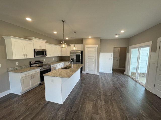 kitchen featuring a center island with sink, stainless steel appliances, hanging light fixtures, and white cabinets