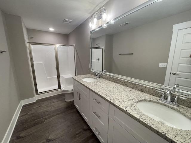 bathroom with vanity, toilet, hardwood / wood-style floors, and walk in shower