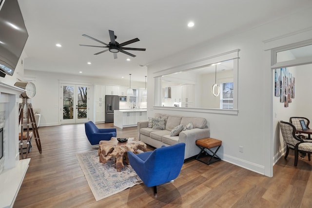 living room featuring hardwood / wood-style flooring, a premium fireplace, plenty of natural light, and ceiling fan