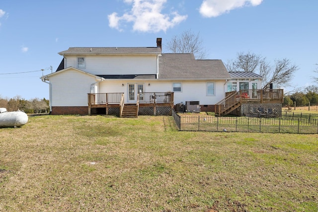 rear view of property featuring a wooden deck, central AC unit, and a lawn