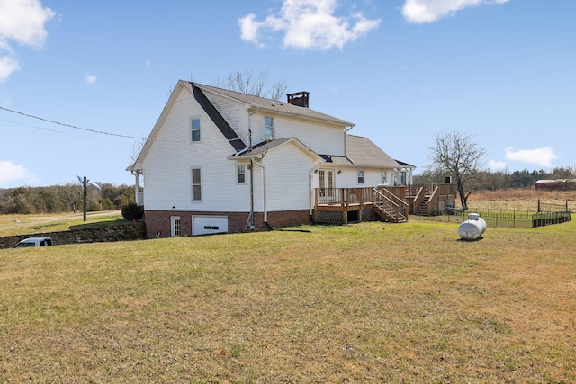 rear view of house with a yard and a deck