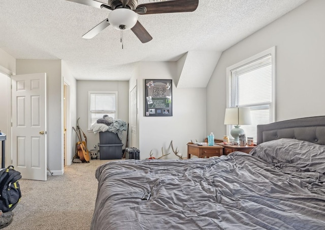 carpeted bedroom featuring ceiling fan and a textured ceiling