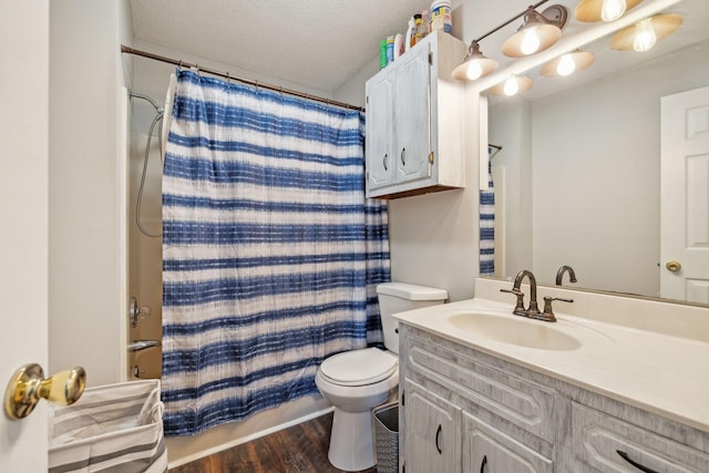 full bathroom featuring shower / tub combo with curtain, hardwood / wood-style flooring, vanity, toilet, and a textured ceiling