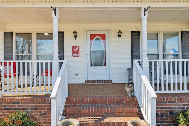 view of exterior entry featuring covered porch