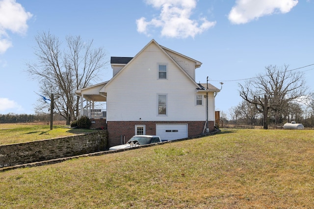 back of house featuring a garage and a yard