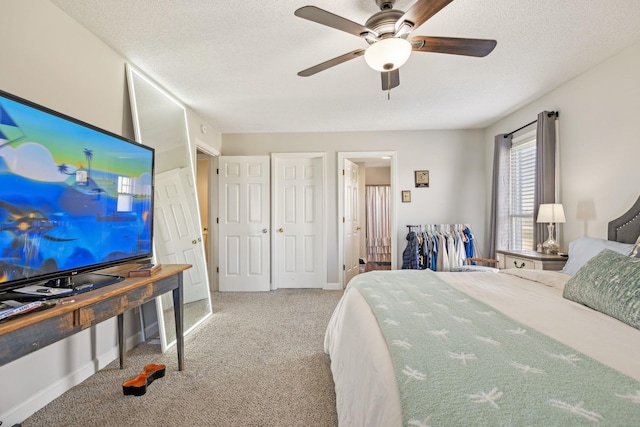 carpeted bedroom featuring ceiling fan and a textured ceiling