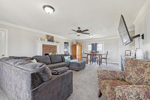 living room with a fireplace, ornamental molding, light colored carpet, ceiling fan, and a textured ceiling