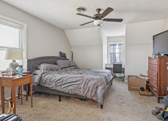 carpeted bedroom with ceiling fan, vaulted ceiling, and a textured ceiling