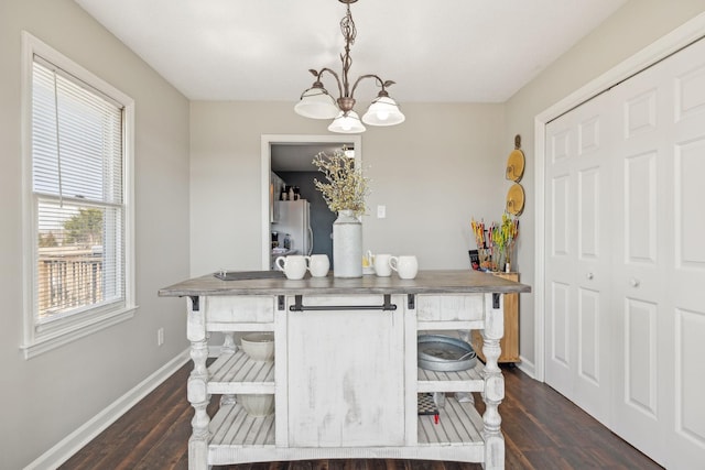 dining area with dark hardwood / wood-style floors and a chandelier