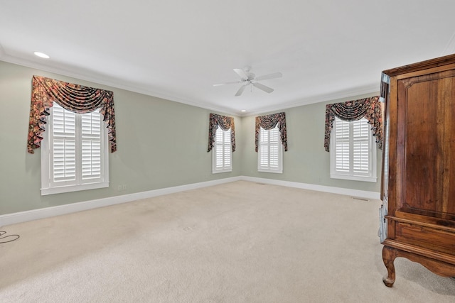 carpeted spare room featuring ornamental molding and ceiling fan