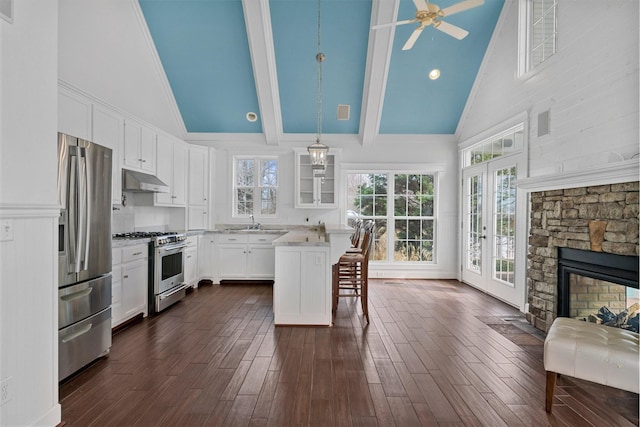 kitchen featuring a breakfast bar area, a center island, appliances with stainless steel finishes, pendant lighting, and white cabinets