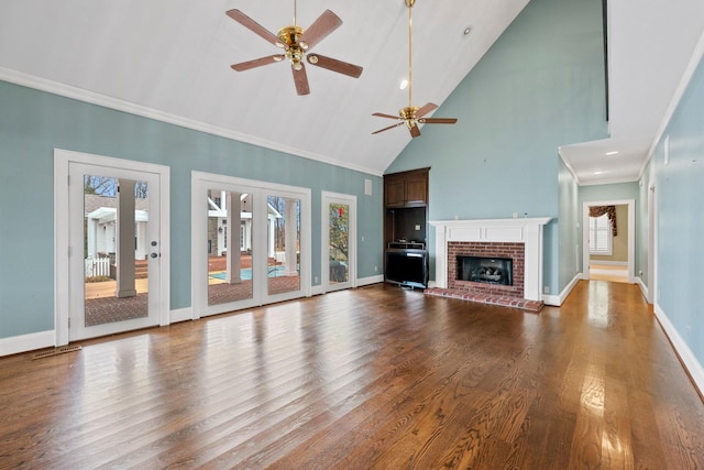 unfurnished living room featuring high vaulted ceiling, wood-type flooring, ornamental molding, ceiling fan, and a brick fireplace