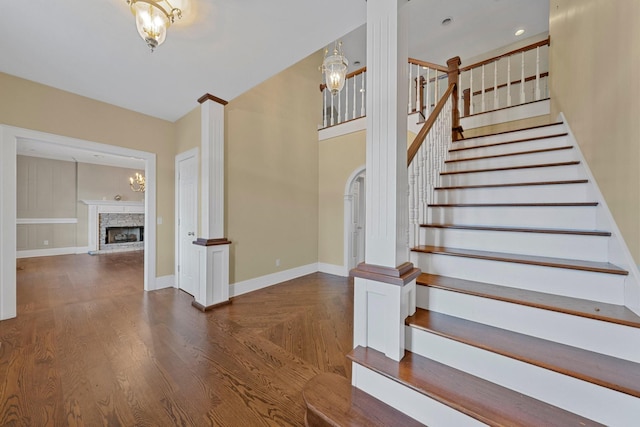 staircase with hardwood / wood-style flooring and a notable chandelier