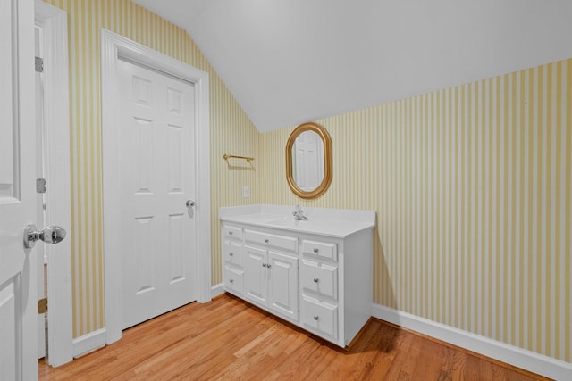 bathroom featuring lofted ceiling, vanity, and hardwood / wood-style flooring