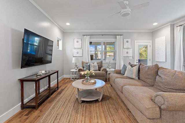 living room with wood-type flooring, ornamental molding, and ceiling fan