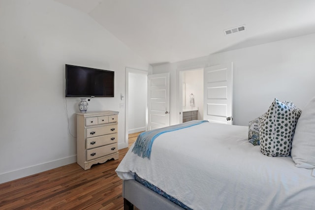 bedroom featuring lofted ceiling, dark hardwood / wood-style floors, and ensuite bathroom