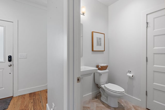 bathroom featuring hardwood / wood-style flooring and toilet