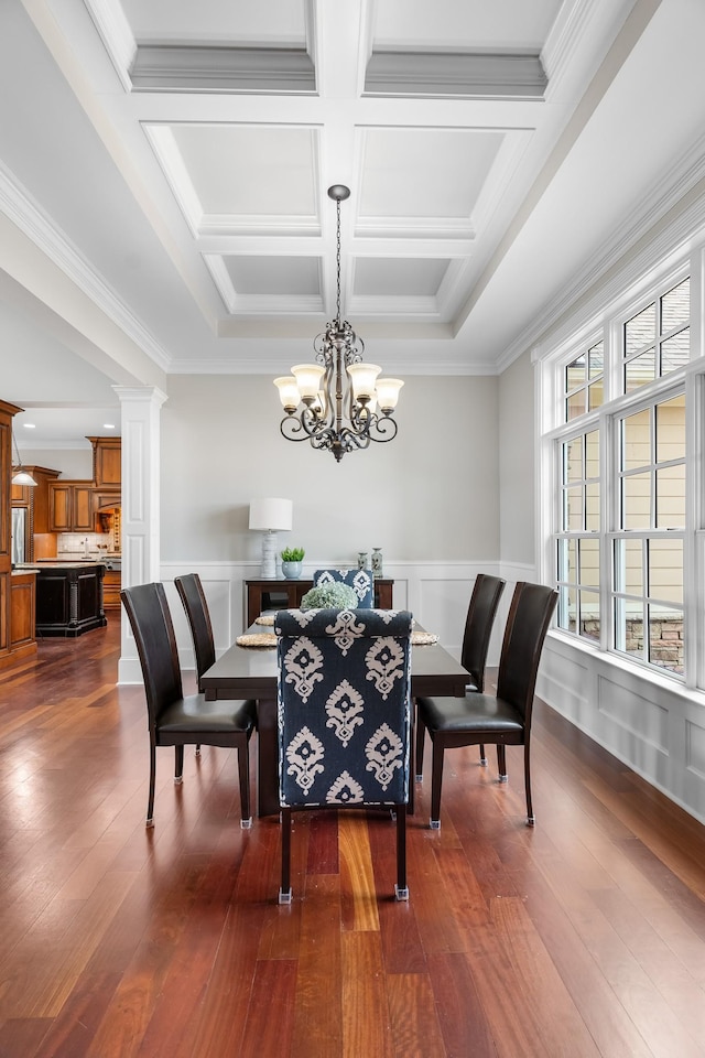 dining space with coffered ceiling, a notable chandelier, ornamental molding, and dark hardwood / wood-style floors