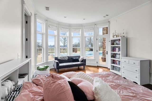 interior space with ornamental molding, access to exterior, and light hardwood / wood-style floors