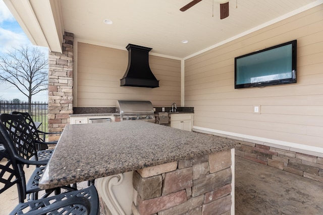 view of patio / terrace featuring area for grilling, ceiling fan, and an outdoor wet bar