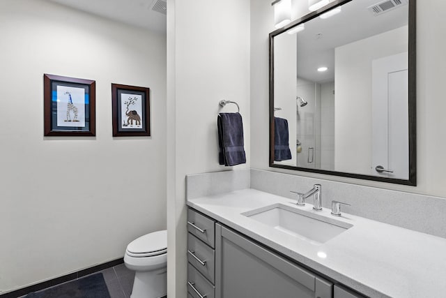 bathroom with tile patterned floors, vanity, toilet, and a shower with shower door