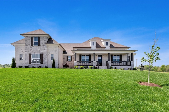 view of front of property with covered porch and a front lawn