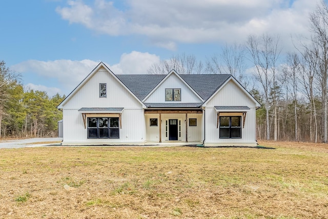 modern inspired farmhouse with a front lawn, a porch, and a shingled roof