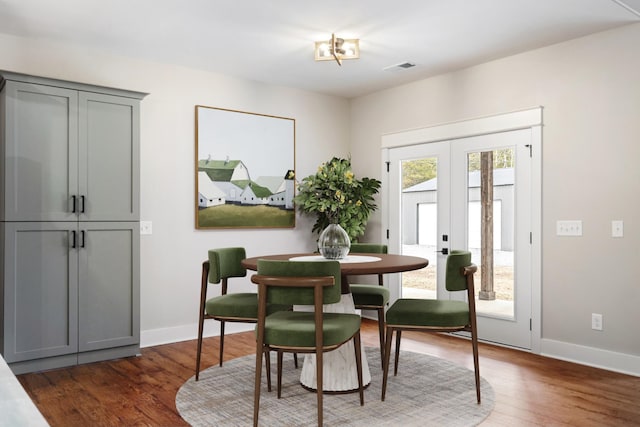 dining area featuring french doors, wood finished floors, visible vents, and baseboards