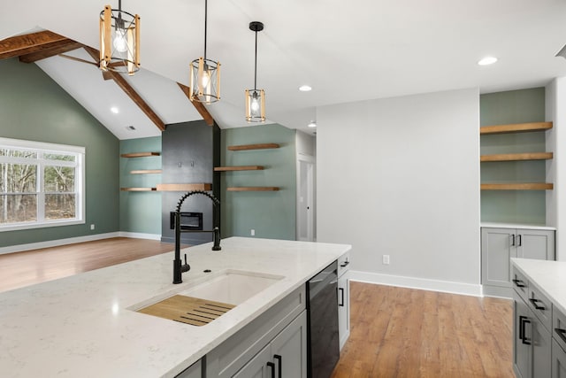 kitchen featuring lofted ceiling with beams, dishwashing machine, a sink, light stone countertops, and open shelves