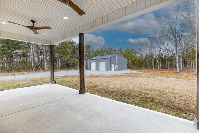 view of patio featuring ceiling fan, a detached garage, and an outdoor structure