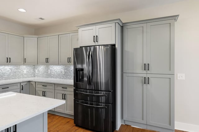 kitchen featuring decorative backsplash, stainless steel fridge, visible vents, and gray cabinetry