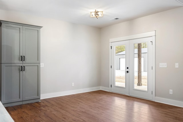 doorway featuring french doors, dark wood-type flooring, visible vents, and baseboards