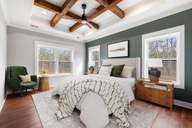 bedroom featuring coffered ceiling, visible vents, baseboards, beam ceiling, and wood-type flooring