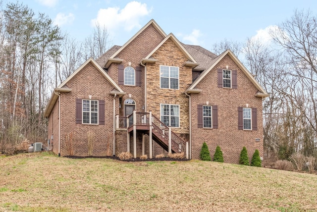 view of front facade with a wooden deck, central AC, and a front lawn