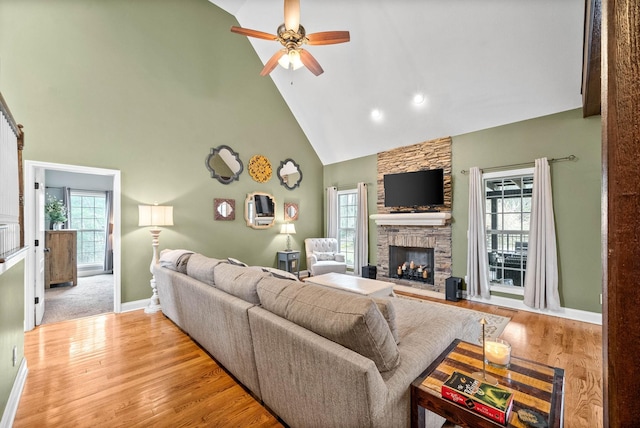 living room featuring a fireplace, a wealth of natural light, light hardwood / wood-style floors, and high vaulted ceiling