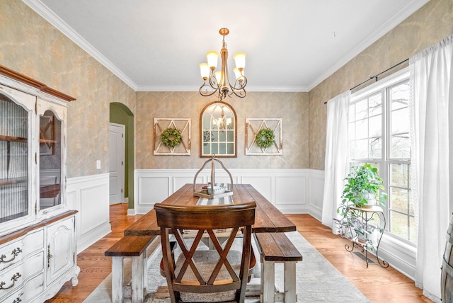 dining area featuring crown molding, a chandelier, and light hardwood / wood-style flooring