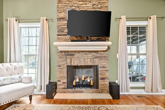 interior details with hardwood / wood-style floors and a stone fireplace