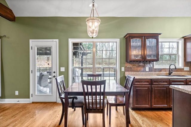 dining area featuring an inviting chandelier, light hardwood / wood-style floors, and sink