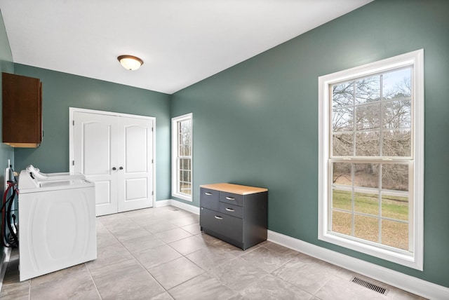 interior space featuring cabinets, light tile patterned floors, and washer and dryer