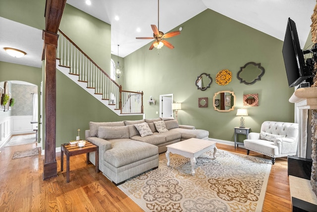 living room featuring ceiling fan, wood-type flooring, and high vaulted ceiling