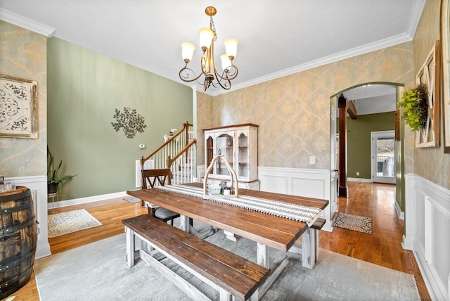 dining space with hardwood / wood-style flooring and ornamental molding