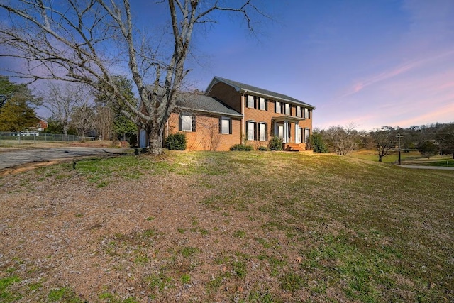 colonial house featuring a lawn and fence